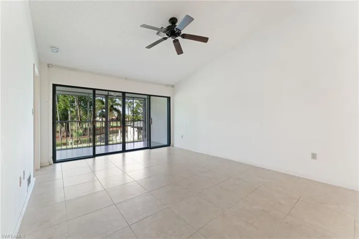 Unfurnished room featuring light tile patterned floors, ceiling fan, and high vaulted ceiling