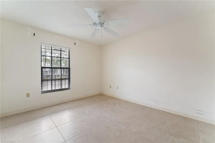 Unfurnished room with a textured ceiling, a ceiling fan, and light tile patterned floors