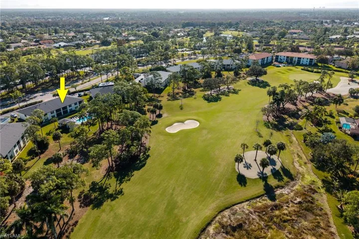 Aerial view of property and surrounding area featuring a golf course