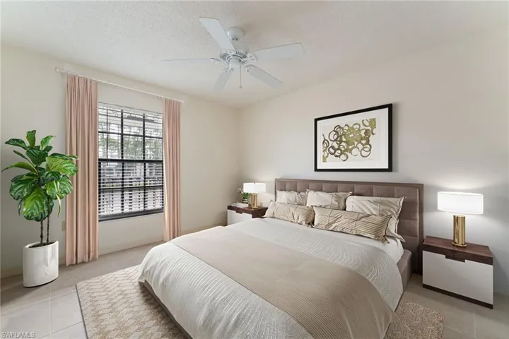 Bedroom with a ceiling fan, light tile patterned flooring, and a textured ceiling