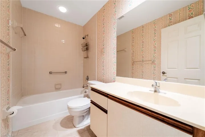 Full bathroom with bathing tub / shower combination, vanity, and light tile patterned flooring