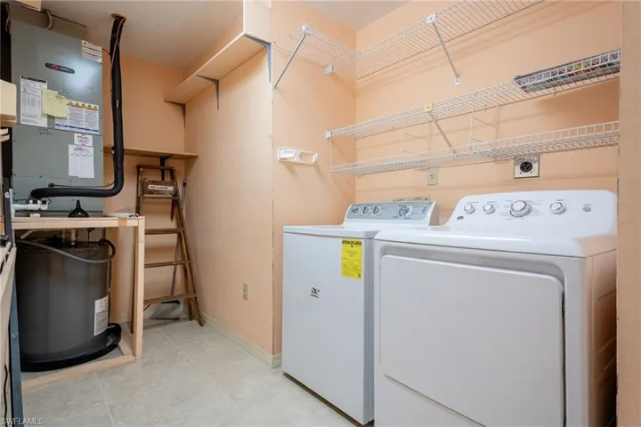 Laundry room with heating unit and washing machine and clothes dryer