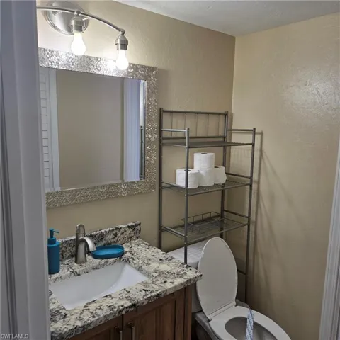 Bathroom featuring a textured wall and vanity