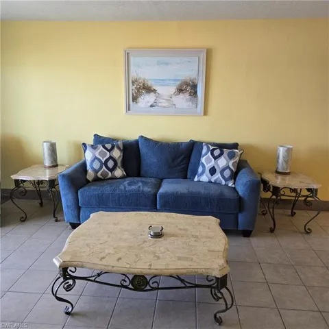 Tiled living area with baseboards and a textured ceiling