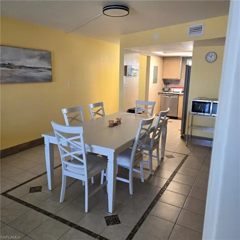 Dining space with light tile patterned floors and inlaid floor details