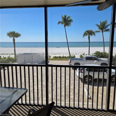 Balcony with view of water and beach and a sunroom