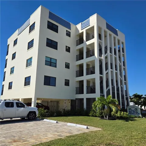 View of apartment building / complex with uncovered parking