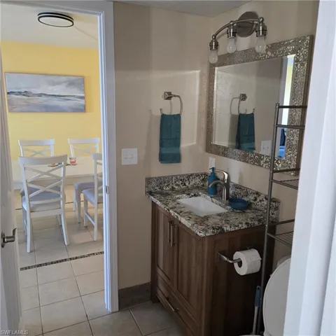Half bath featuring vanity and light tile patterned floors