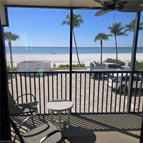 Balcony with ceiling fan and view of water and beach