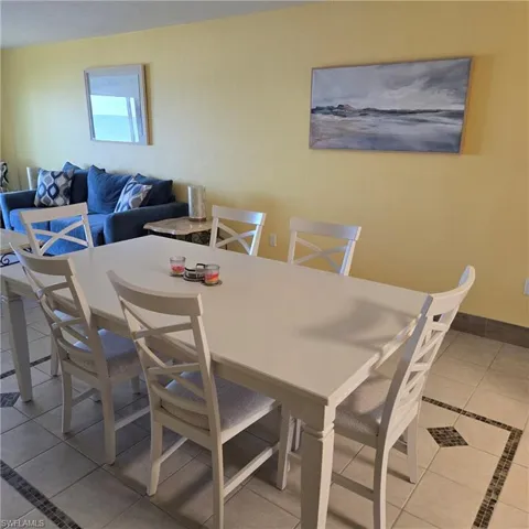 Dining room featuring light tile patterned floors and inlaid floor details
