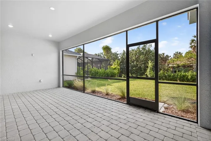 The property features a screened patio with a light-colored paver floor and recessed lighting