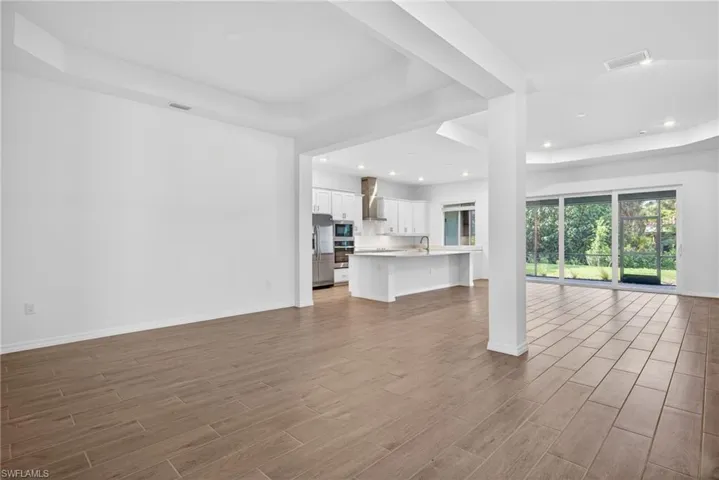 Dining area featuring light wood-look tile flooring, white walls, and a tray ceiling