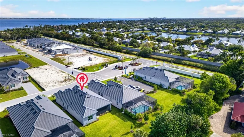 Aerial view featuring the property with a dark tile roof, green lawn, and a screened-in pool