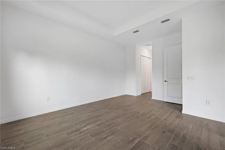 Primary Bedroom with light wood-style flooring, white walls, and a white ceiling