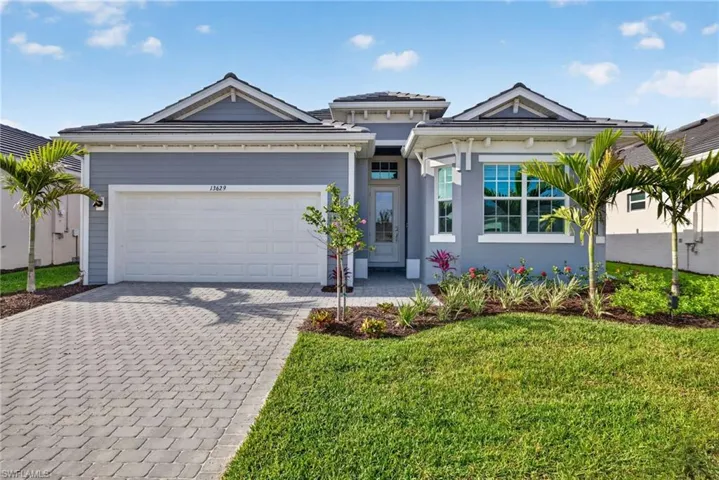 The property features a well-maintained lawn, mature palm trees, and decorative landscaping