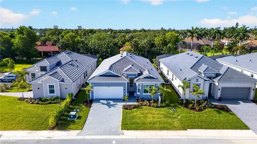 The property features a well-maintained lawn and a paved driveway leading to an integrated garage