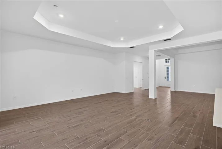 Expansive open concept living area featuring wood-look tile flooring, white walls, and recessed lighting