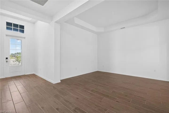 Dining area featuring light wood-look tile flooring, white walls, and a tray ceiling