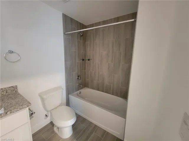 Bathroom featuring vanity, wood finish floors, and  shower combination