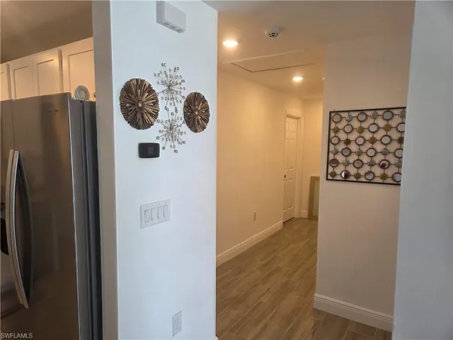 Corridor with wood finish floors and recessed lighting