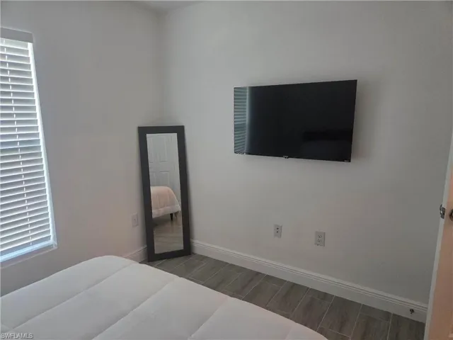 Bedroom featuring wood finish floors and baseboards