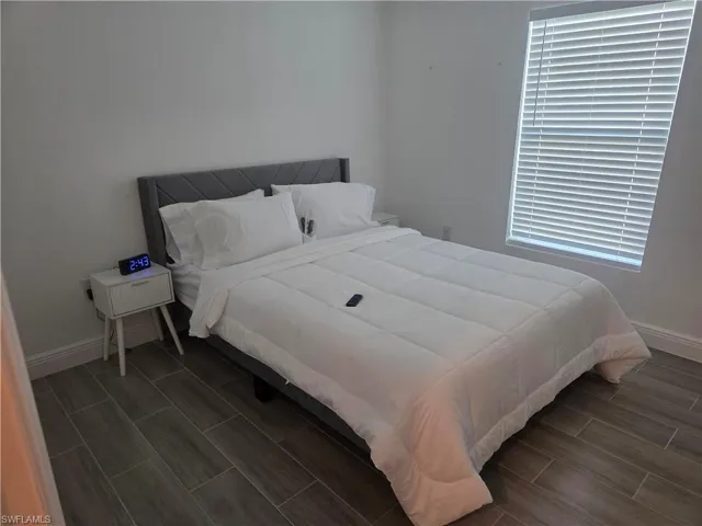 Bedroom with baseboards and wood finish floors