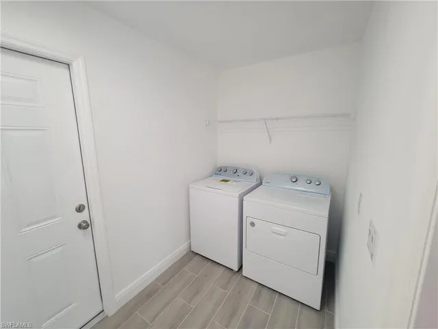 Laundry area featuring washing machine and dryer and wood tiled floors