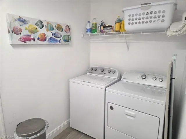Laundry room with light wood-style flooring and washer and dryer