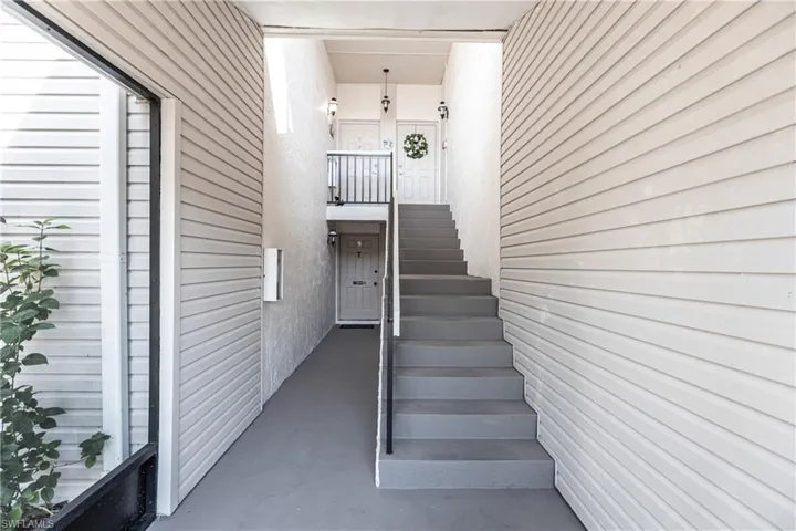 Stairs featuring finished concrete flooring and wood walls