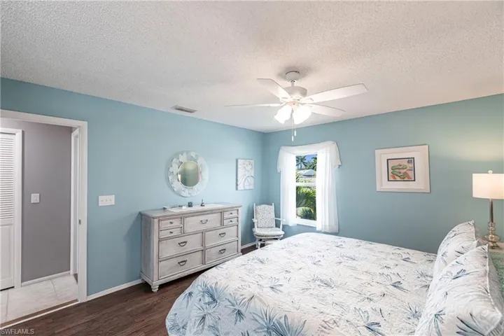 Bedroom featuring dark wood-style floors, ceiling fan, and a textured ceiling