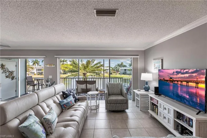 Tiled living area featuring a textured ceiling and crown molding