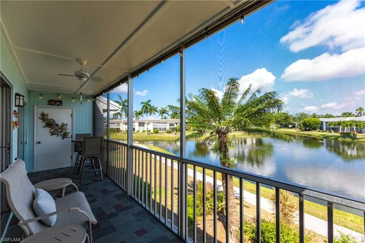 Sunroom / solarium featuring ceiling fan, a water view, and a balcony