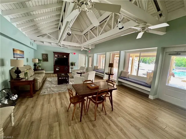 Dining room with high vaulted ceiling, a wooden ceiling with exposed beams, light wood-style flooring, and ceiling fan