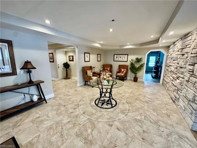 Living area with arched walkways, recessed lighting, and a tray ceiling