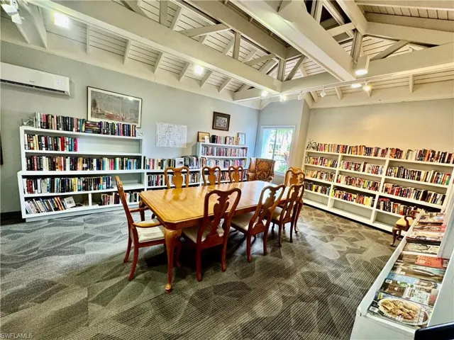 Living area featuring bookshelves and a wall mounted air conditioner