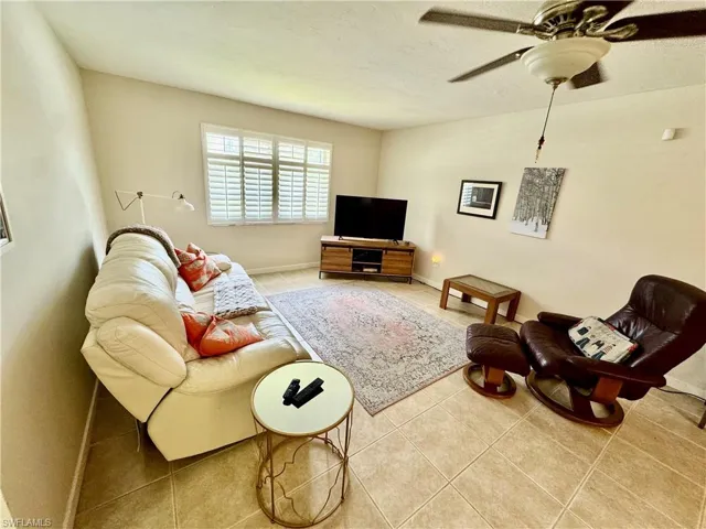 Living room with tile patterned flooring and a ceiling fan