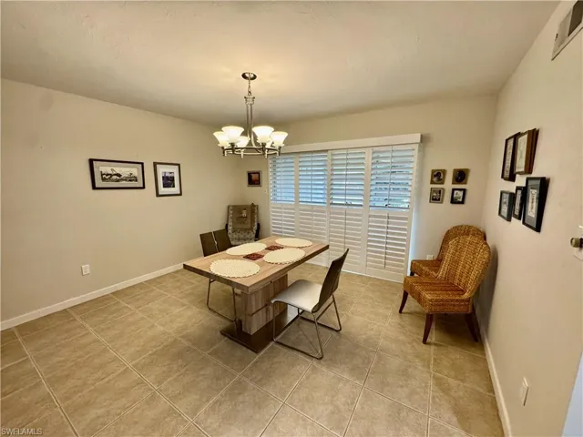 Dining space featuring light tile patterned flooring and a chandelier