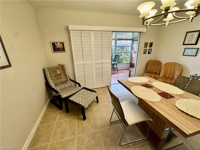 Dining area with light tile patterned flooring and a chandelier