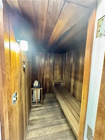 Sauna featuring wood ceiling and wooden walls