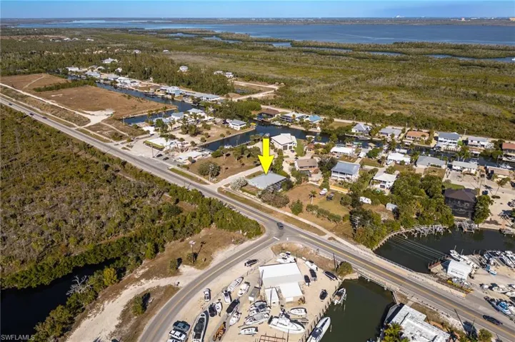 Aerial view of property's location with a large body of water and nearby suburban area
