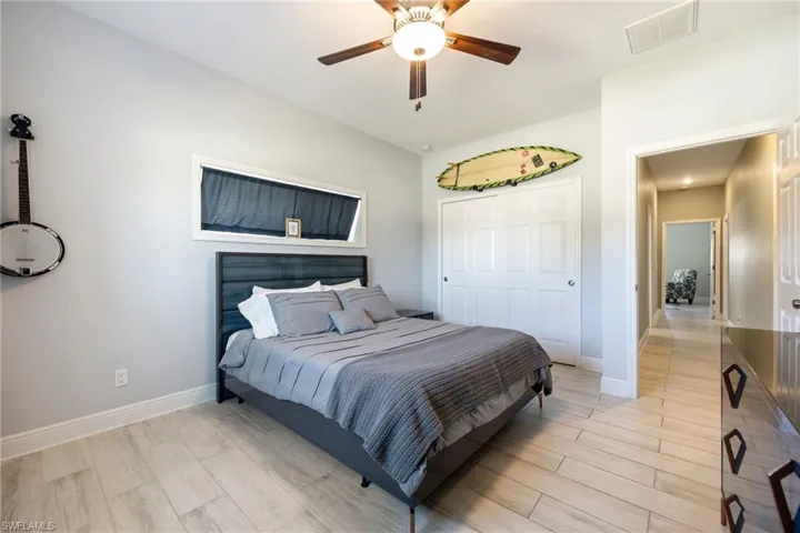 Bedroom with wood finish floors, ceiling fan, and a closet