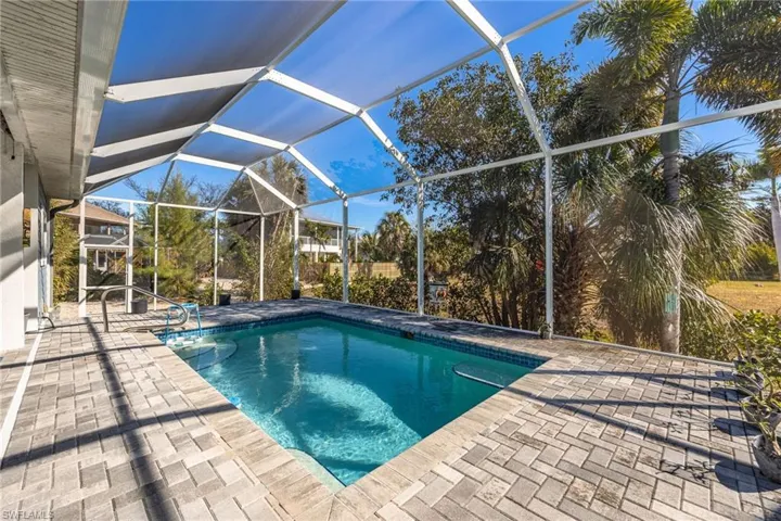 Swimming pool with a sunroom, glass enclosure, and a patio