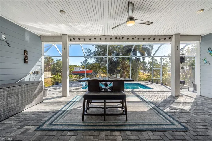 View of patio with a sunroom, glass enclosure, an outdoor pool, and a ceiling fan
