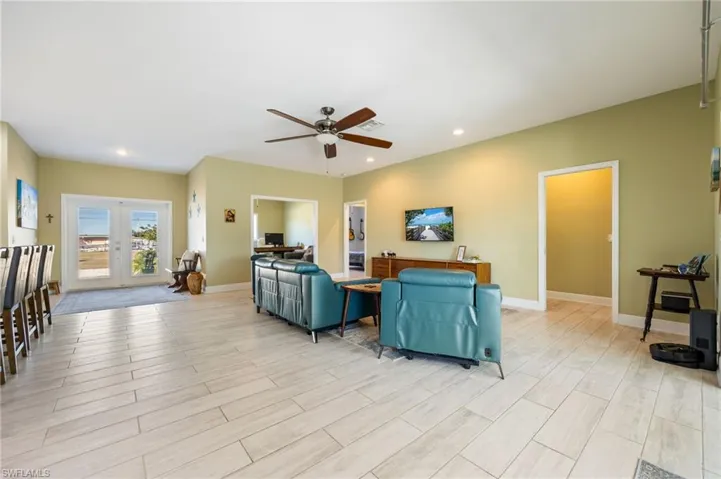 Living area featuring a ceiling fan, french doors, wood finish floors, and recessed lighting