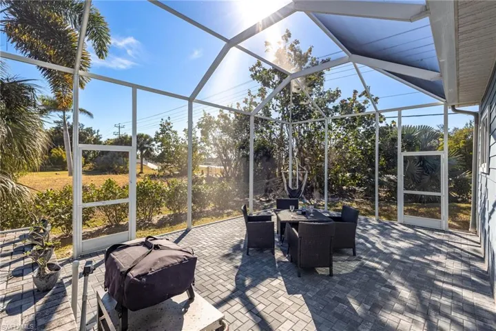 View of patio / terrace featuring a sunroom, a lanai, and outdoor dining area
