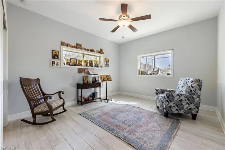 Sitting room featuring wood tiled floors and ceiling fan