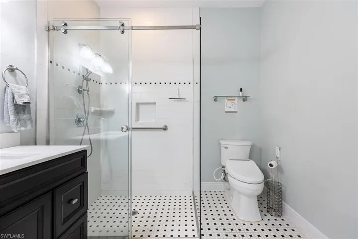 Full bath featuring a shower stall, vanity, and light tile patterned floors