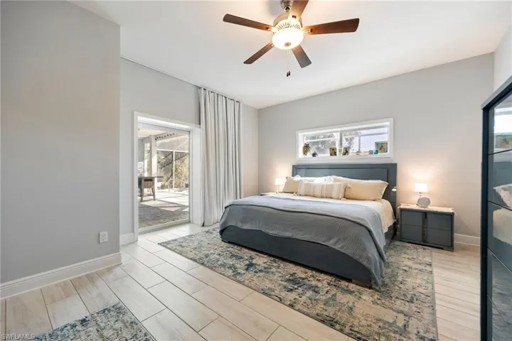 Bedroom featuring access to exterior, wood tiled floors, and a ceiling fan