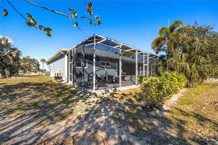 Back of house with a sunroom and glass enclosure