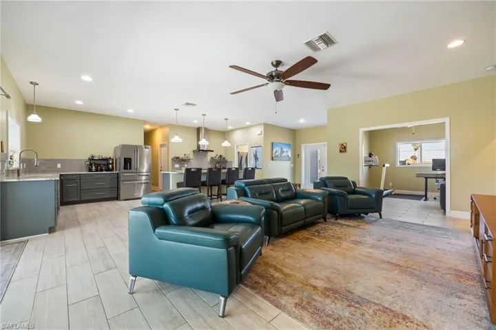 Living room featuring wood tiled floors, a ceiling fan, and recessed lighting